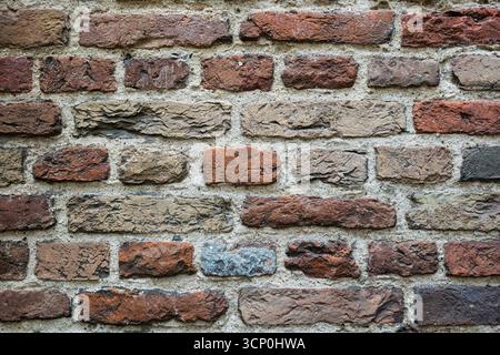 Old, weathered, colorful brick wall pattern or background. Front view, close up, no people Stock Photo