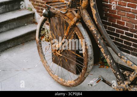 Completely rusty old bicycle on a street corner. Top down, close up view, no people Stock Photo