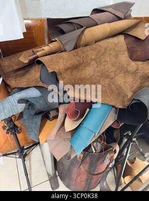 Table covered in fabric scraps showcases creativity and materials for crafting leather goods. Stock Photo