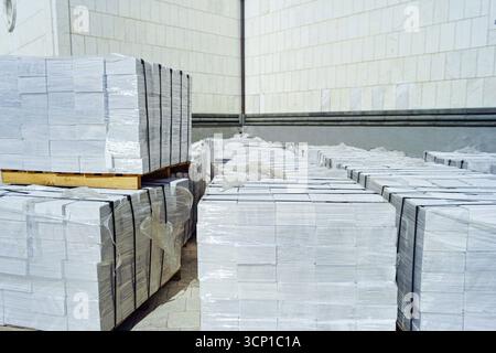 Wrapped in film white stone blocks for facade cladding. Durable exterior finishing material used in modern architecture and decorative wall covering Stock Photo