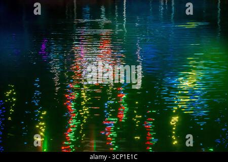 Colorful Neon Reflections on Night Water: Vibrant City Lights Shimmering Across the Surface Stock Photo