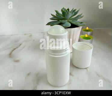 Cosmetic roll-on deodorant with candles and succulent plant for spa wellness Stock Photo