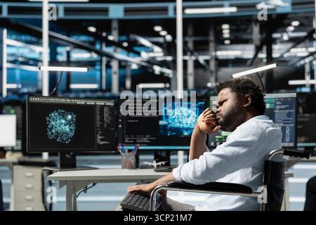 Data center worker with disability in wheelchair using deep learning algorithms to analyze datasets. Person with paraplegia in inclusive server hub using AI to recognize data patterns Stock Photo