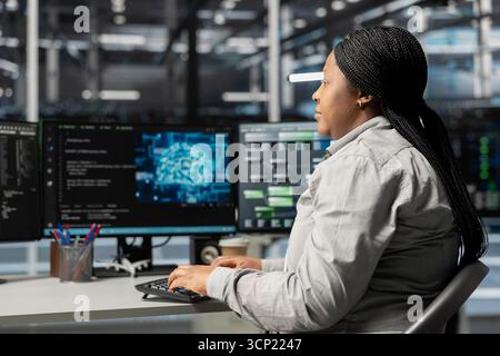 Data center computer scientist using artificial intelligence neural networks technology. Woman working in server room using AI programming language on computer, configuring specialized hardware Stock Photo