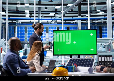 Investors evaluating factory production during presentation on isolated screen monitor. Shareholders meeting with industrial plant managers to understand business model presented on chroma key display Stock Photo