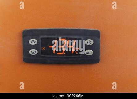 thermostat industrial, regulation panel, frost setting, digital display digits, orange, white buttons with arrows Stock Photo