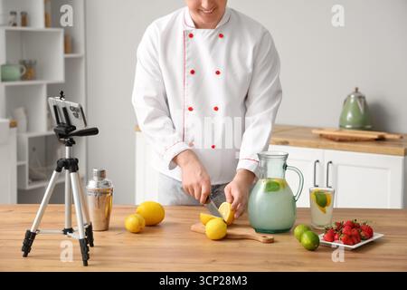 Male chef recording video of him making homemade lemonade in kitchen Stock Photo