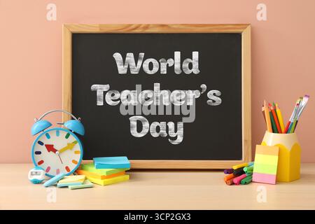 Happy Teacher's Day greeting card with stationery and text on small chalkboard Stock Photo