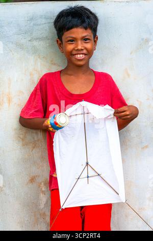 Smiling Filipino boy holding a simple kite in Palawan, Philippines Stock Photo