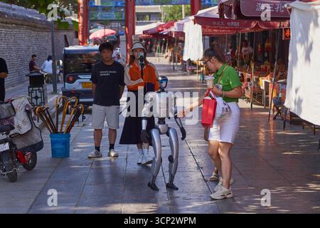 Humanoid robot interacting and walking through the streets of Qufu in China Stock Photo
