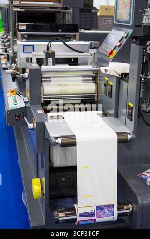 Close-up of an industrial label printing machine with digital control panel running flexible packaging material. Modern high-speed printing and packag Stock Photo