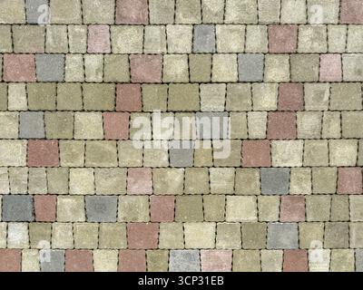 shallow multicolored square paving tiles on the pavement. paving stones pattern. highly detailed textured background. Stock Photo