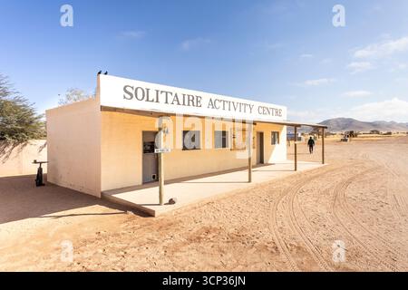 Solitaire Activity Centre in Namibia - 27 August, 2025, surrounded by golden sand dunes and rugged mountains under a clear sky. Stock Photo