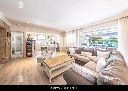 Modern Open Plan Living Room with Sofa and View to Backyard in mediterranean apartment Stock Photo