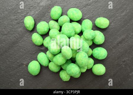 Pile of delicious wasabi coated peanuts on dark textured table, flat lay Stock Photo