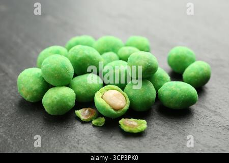 Pile of delicious wasabi coated peanuts on dark textured table, closeup Stock Photo