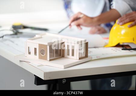 Architectural model on table with engineers discussing plans Stock Photo