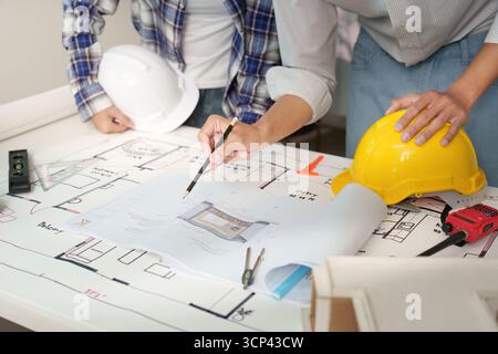 Engineers reviewing construction plans in modern workspace Stock Photo