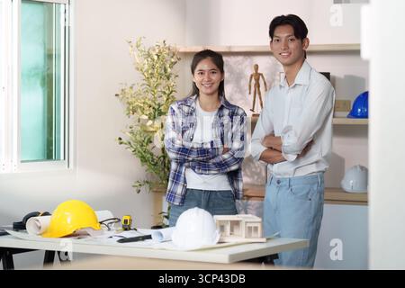 Engineer collaboration. Young engineers discussing architectural plans in a modern workspace. Stock Photo