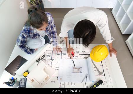 Engineer collaborating on architectural plans with a colleague Stock Photo