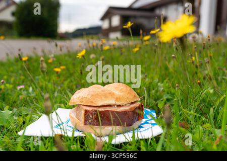 Bavaria, Germany - September 17, 2025: Bavarian Leberkässemmel as a snack in an outdoor meadow *** Bayerische Leberkässemmel als Brotzeit in einer Wiese im Freien Stock Photo