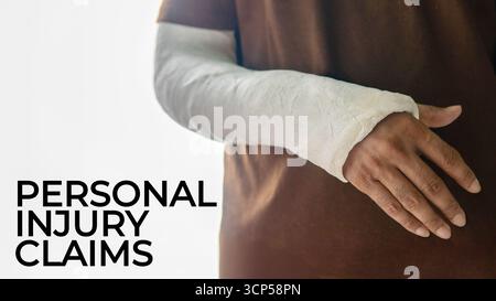 A person's arm encased in a white plaster cast with text PERSONAL INJURY CLAIMS. Medical and healthcare concept. Stock Photo