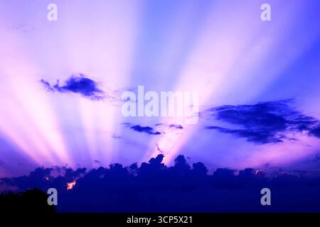 Majestic Crepuscular Rays Bursting Through Clouds Stock Photo