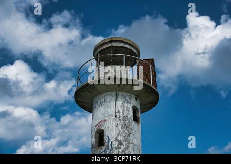 Old Weathered Lighthouse Against Blue Sky Stock Photo
