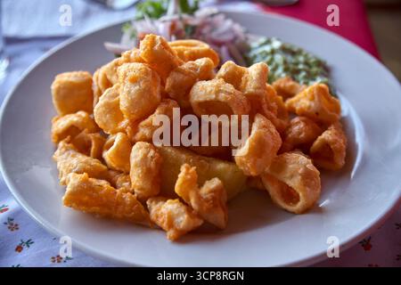 Peruvian Chicharrón de Calamar is a delightful dish featuring deep-fried calamari, often served as an appetizer or snack. It's known for its crispy te Stock Photo