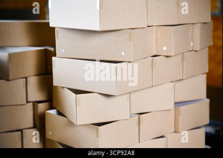 Cardboard box blanks stacked neatly in a manufacturing facility ready for assembly and distribution Stock Photo