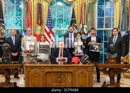 President Donald J. Trump poses with Israeli hostage families in the Oval Office, as participants display photos and signs urging action for those still held by Hamas in Gaza. Washington, D.C. September 9, 2025. Image courtesy of the White House. Image courtesy of the White House. Stock Photo