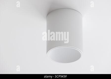 A clean, white cylindrical ceiling light creates focused illumination with a contemporary, minimalist vibe. Perfect for modern living rooms, kitchens, Stock Photo
