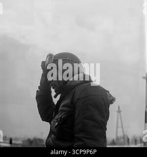 A powerful close-up portrait from 1975 shows an exhausted Soviet motocross racer, his face spattered with mud, shortly after a grueling winter race in Sloviansk, Ukrainian SSR. The rider, wearing a vintage helmet with goggles pushed up, reveals the physical toll and sheer determination required for the demanding sport. This black-and-white photograph is a timeless and gritty depiction of the endurance and spirit of an athlete Stock Photo