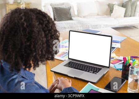 African American woman sketching color swatches on home office table with laptop, copy space Stock Photo