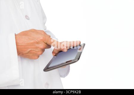 Hands wearing white lab coat tapping touchscreen tablet on plain white background, copy space Stock Photo