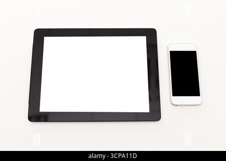 Tablet and smartphone placed on a white surface for digital display or design purposes Stock Photo