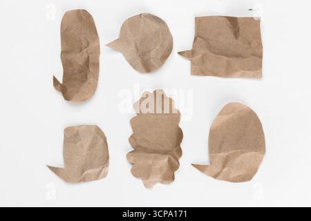 Various crumpled paper shapes suggestive of speech bubbles on a plain background Stock Photo