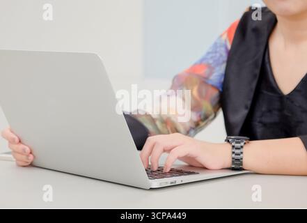 Close-up young Asian working woman who typing keyboard on portable computer laptop for contact customer on work from home Stock Photo