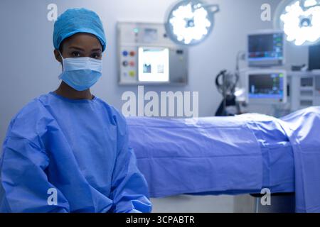 African American female surgeon adjusting light in operating room above operating table, copy space Stock Photo