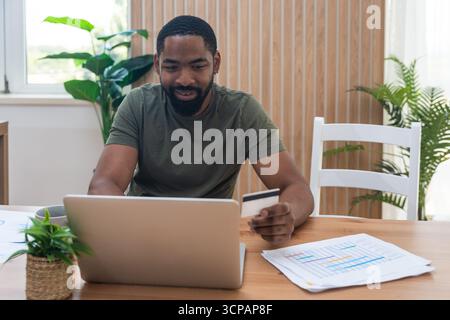 Young university student, freelancer business man, working at home on laptop computer, testing new innovative technology and online internet tools whi Stock Photo
