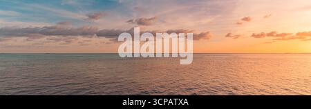 Picturesque panoramic colorful sunset over sea with glowing sky, dramatic clouds, radiant sun rays, dream peaceful nature background, inspire horizon Stock Photo