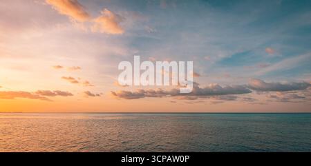 Picturesque panoramic colorful sunset over sea with glowing sky, dramatic clouds, radiant sun rays, dream peaceful nature background, inspire horizon Stock Photo