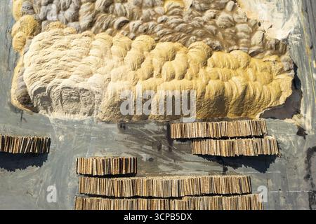 Aerial view of an art installation with rough, textured beige and grey elements contrasting with stacked wooden structures on a smooth, dark surface, Graz, Styria, Austria. Stock Photo