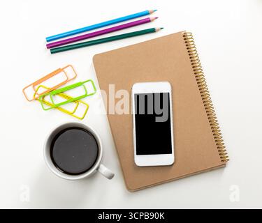 Stationery and coffee setup on a desk with colorful pencils and smartphone Stock Photo
