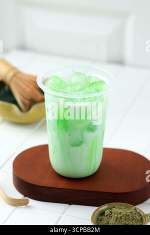 Iced Green Tea Syrup on Plastic Cup, on White Wooden Table Stock Photo