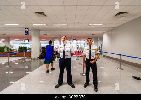 Two security guards smiling inside NAIA Terminal 3 airport in Manila, Philippines Stock Photo
