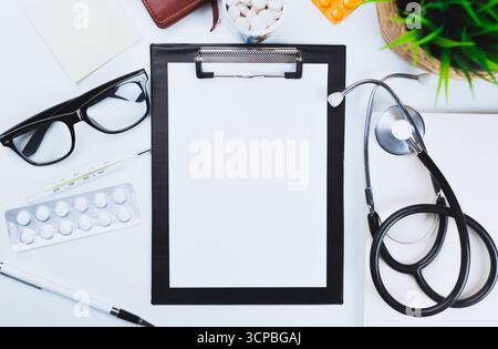 Medical workspace with clipboard, stethoscope, glasses, and medication on a clean desk Stock Photo