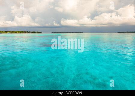 Tranquil and serene overcast tropical sea bay landscape background. Calm waters, soft cloudy sky, peaceful nature travel destination view. Seascape Stock Photo