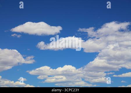 White clouds blue sky background. White fluffly clouds texture. Stock Photo