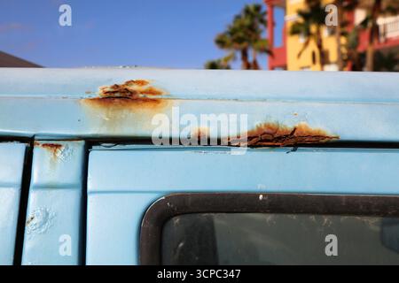 Rusting body in an old blue car. Weather damage in vehicle. Stock Photo